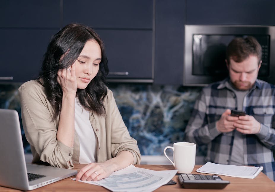 Couple experiencing stress while managing household finances at home.